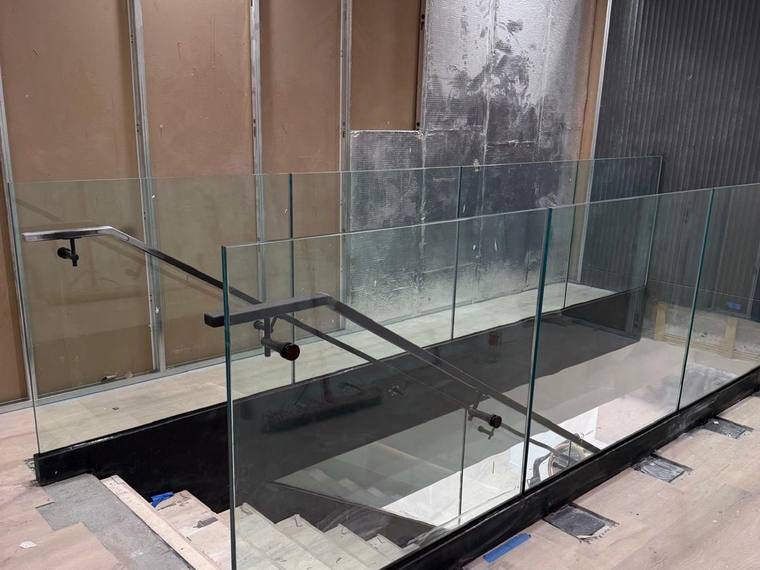 Glass guard running along an opening at floor level.