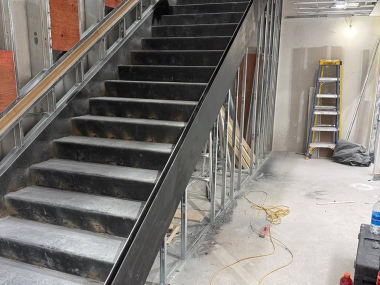 Steel stair structure set inside stud framing.