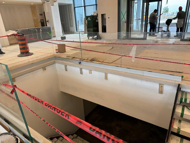 Glass guard around a stair opening in a commercial interior.