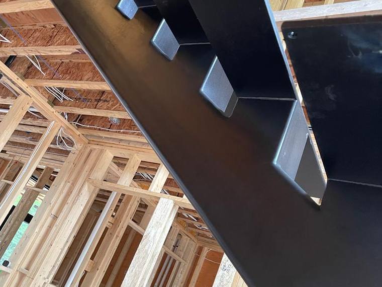 Blackened steel mono-stringer stair set in timber framing.