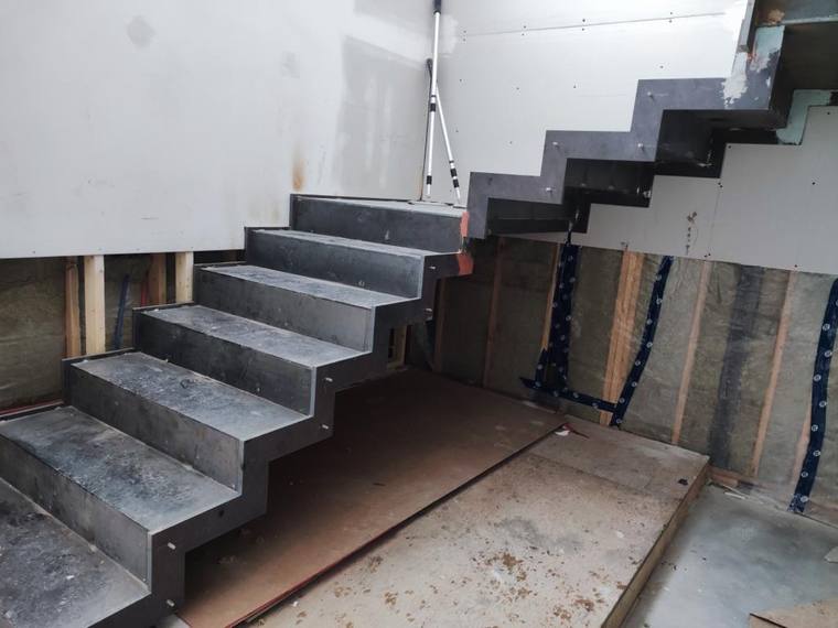 Steel stair seen from below, showing the underside of the treads.