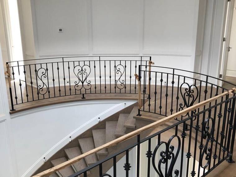 Landing guard with hand-formed iron scrollwork.