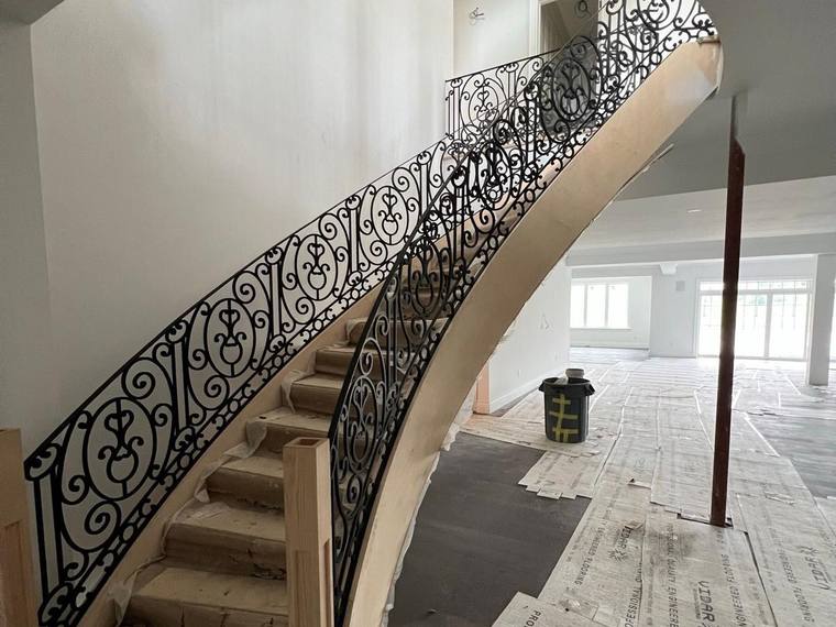 Finished curved iron guard on an interior landing.