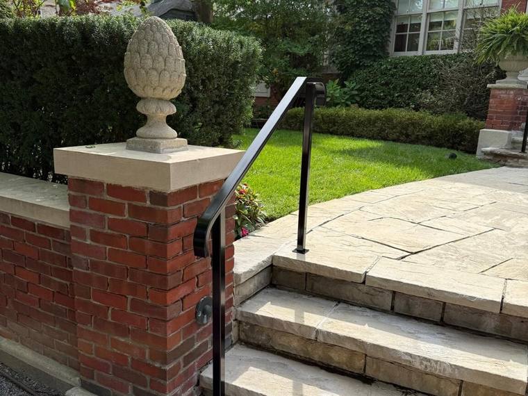 Exterior handrail returning into a brick pillar.