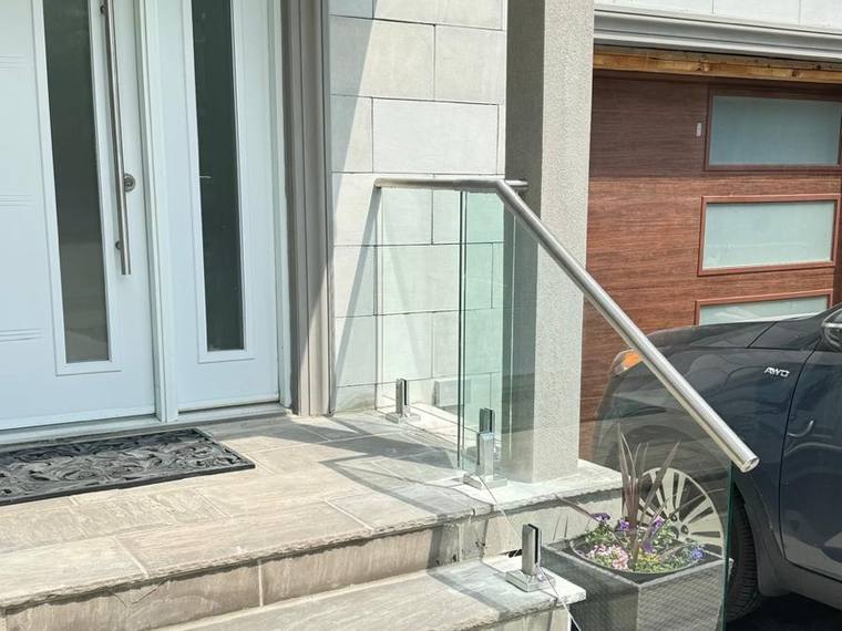 Close view of a glass and stainless entrance railing.
