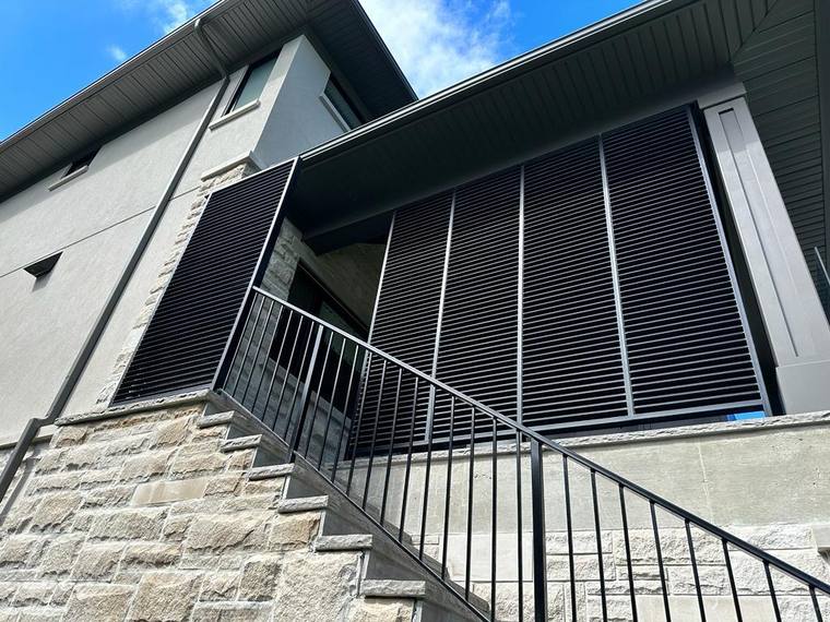 Laser-cut metal privacy screen beside an exterior stair.