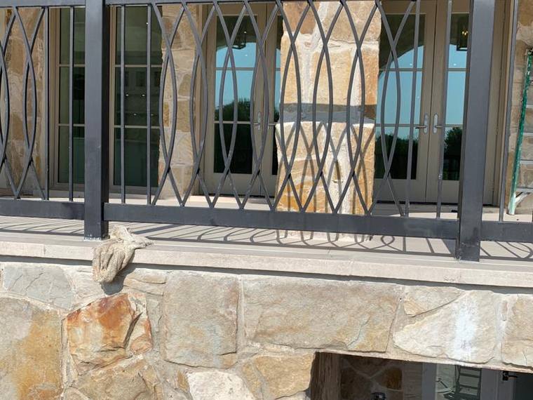 Ornamental iron grilles set into arched stone window openings.