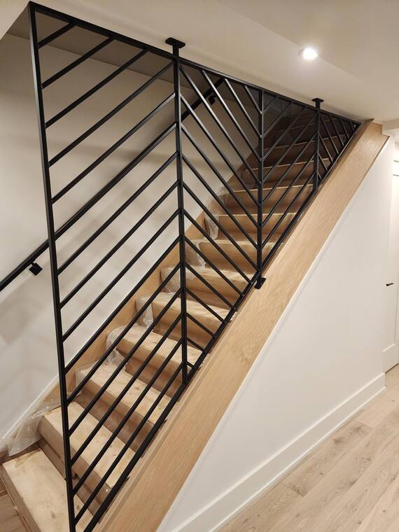 Escalera interior con barandal de espiga y pasamanos de roble.