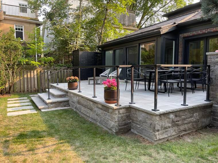Patio with a glass guard over a stone base.